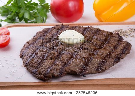 Prepared Steak Served With Butter On Wooden Board