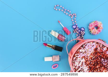 Female Backpack With Cosmetics And Women's Accessories On Blue Background. Top View, Flat Lay.
