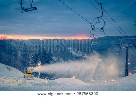 Snow Making Machine On The Hill Working On The Ski Run In Evening