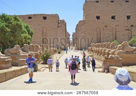 Karnak, Egypt - 17th May, 2018: Tourists Walk To The Entrance Of The Temple Of Karnak. View Of The F