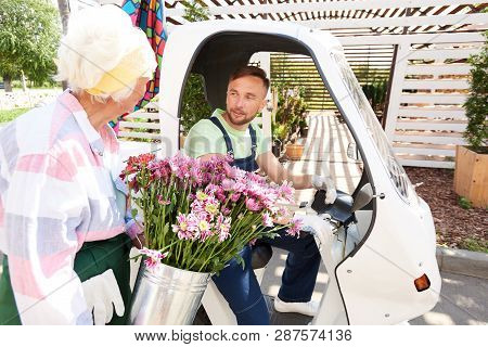 Portrait Of Handsome Man Delivering Flowers Sitting In Car On Plantation Lit By Sunlight, Copy Space