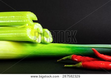 Fresh Vegetables: сelery, Leek And Chili Pepper On Black Background. Healthy Food.