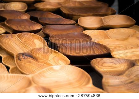 Close Up Of Wooden Utensils For The Kitchen, Bowls, Plates On Dark Background. Concept Of Natural Di
