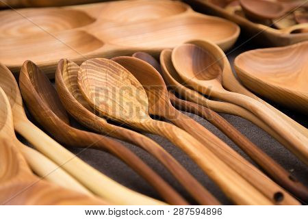 Close Up Of Wooden Utensils For The Kitchen, Bowls, Spoons On Dark Background. Concept Of Natural Di