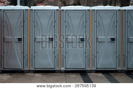 Long Row Of Mobile Toilets Outside In The City. Bio Toilets Outdoors