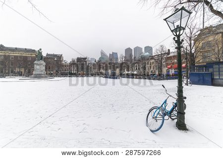 Bicycle Locked With The Lamp Post At The Central Place Covered By Snow, Plein (dutch), Usually Crowd