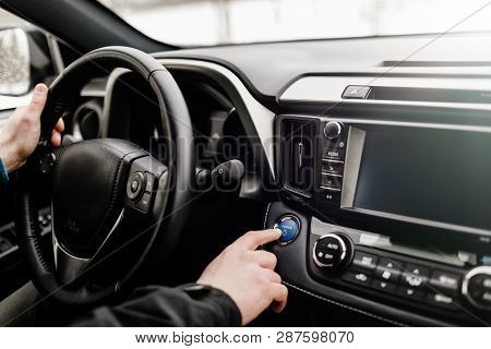Driver Pushing Car Engine Start-stop Button In Modern Car.