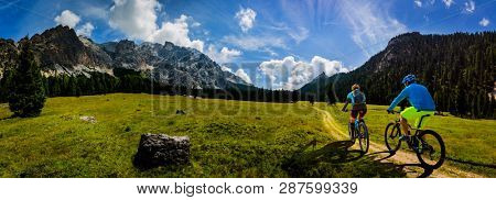 Mountain cycling couple with bikes on track, Cortina d'Ampezzo, Dolomites, Italy