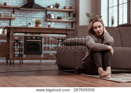 Depressed Wife Sitting On The Floor While Feeling Stressed