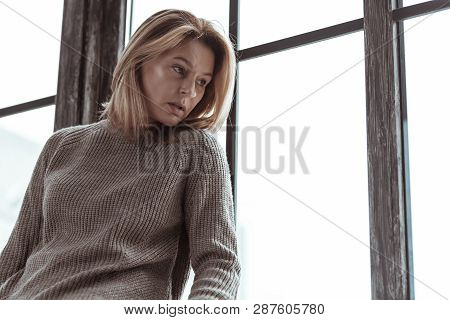 Stressed Woman Wearing Sweater Sitting Near The Window