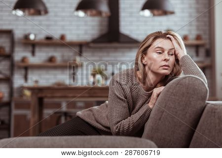 Mature Family Woman Sitting On The Sofa Feeling Stressed
