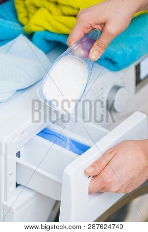 Washing Powder Detergent And Measuring Cup Pouring Into Machine. Household Duties, Clothes Laundry O