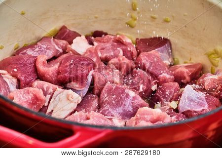 Preparing Perkelt Sauce - Pouring Salt On Meat In Red Pot
