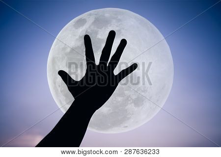 Silhouette Of A Hand With Large Full Moon On Fantastic Sky Background. Symbol Is Mean To Say Hi , Fi