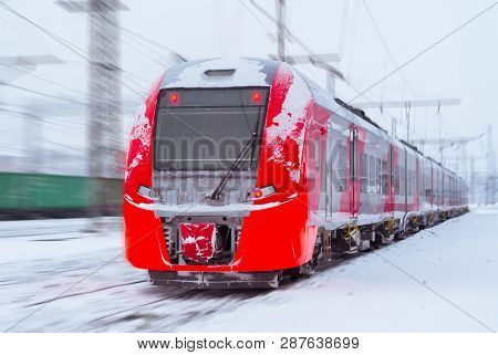 Ice-covered Electric Multiple Unit Train Rushes Along A Blurred Winter Railway Landscape