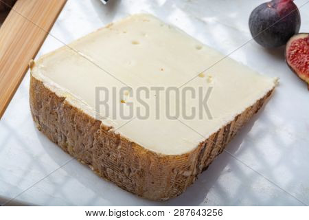 Piece Of French Cheese Tomme De Brebis Made From Sheep Milk Served As Dessert With Fresh Figs And Pe