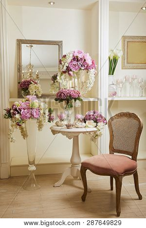 Interior Of Room With Chair, Mirror, Bouquets In Glass Vases