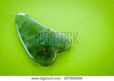 Guasha Scrapers For Body Massage According To The Ancient Method Shot On A Bright Green Background