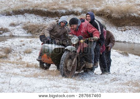 A Team On A Soviet Retro Motorcycle With A Sidecar In The Mud And Snow Riding Cross-country