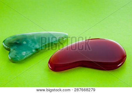 Guasha Scrapers For Body Massage According To The Ancient Method Shot On A Bright Green Background