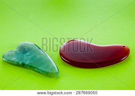 Guasha Scrapers For Body Massage According To The Ancient Method Shot On A Bright Green Background