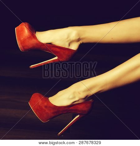 Two Straight Beautiful Female Legs In Suide Luxury Red Elegant Shoes With High Heels On Dark Backgro