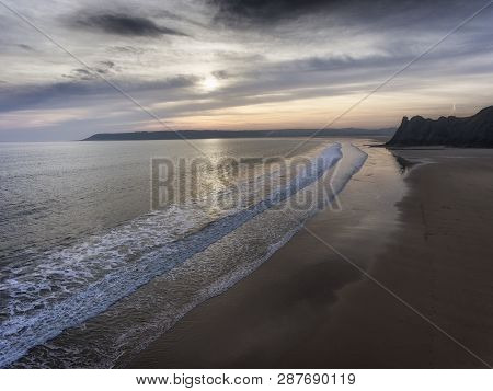 Dusk At Three Cliffs Bay Showing The Great Tor And Oxwich Bay On The Gower Peninsula In Swansea, Sou
