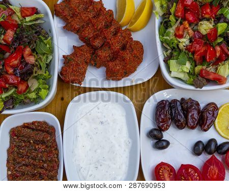 Appetizer Table. The Background Consisting Of Salad, Yogurt, Olives, Raw Meatballs And Appetizers.  