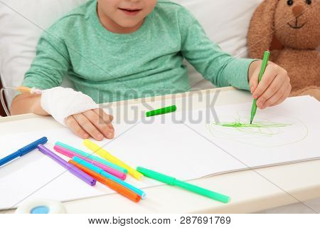 Little Child With Infusion Drip Drawing In Hospital Bed, Closeup
