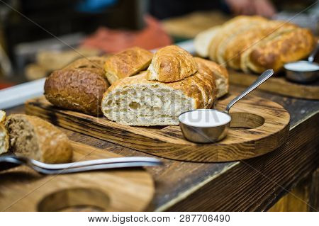 Cutting Board With Different Types Of Bread, Gravy Boat With Butter