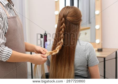 Professional Coiffeuse Braiding Client's Hair In Salon