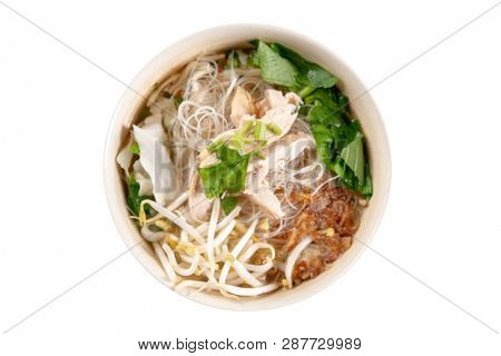 Asian rice noodles soup with vegetables and chicken in bowl. Top view flat lay isolated on white background.