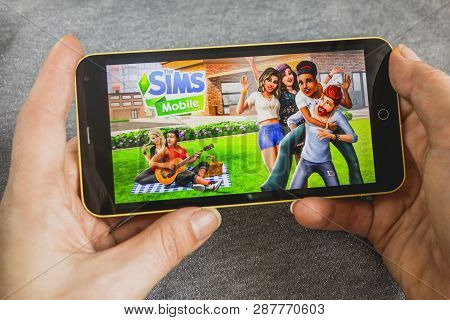 Berdyansk, Ukraine - March 4, 2019 - Close Up Of Hand Of Person Playing The Sims Mobile Game Apllica