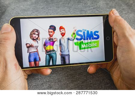 Berdyansk, Ukraine - March 4, 2019 - Close Up Of Hand Of Person Playing The Sims Mobile Game Apllica