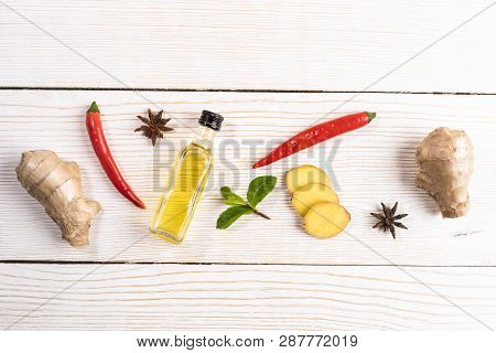 Layout Of Condiments With Ginger And Ginger Oil  On Light Wooden Background.