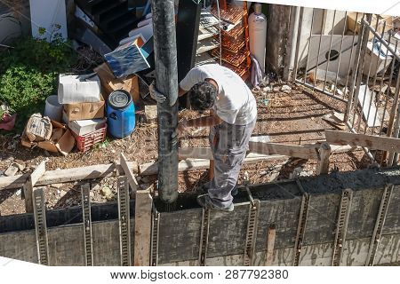 Limassol, Cyprus - April 3, 2018:  Man Standing On Shuttered Wall Holding The Chute And Pouring Ceme