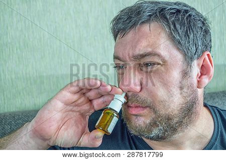 Man With Runny Nose Treats Nose With Nasal Spra
