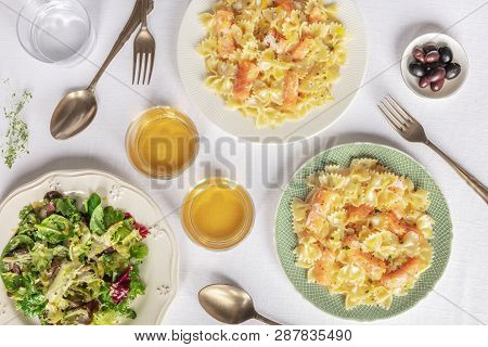 Two Plates Of Salmon Pasta. Farfalle With Smoked Salmon And Cream Sauce, Shot From The Top With Wine