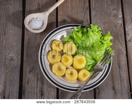 Ready-made Potato Gnocchi With Leaves Of Fresh Leaf Lettuce On A Ceramic Plate With Stripes, A Table