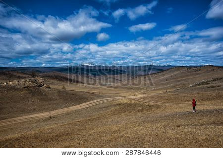 Wide Steppe With Yellow Grass Under A Blue Sky With White Clouds With Silhouette Of Girl, Tazheran S