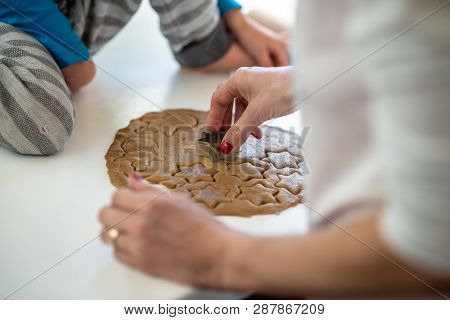 Closeup View Of Mother And Child Making Cookies Pressing Star Shaped Cookie Cutter In A Rolled Whole