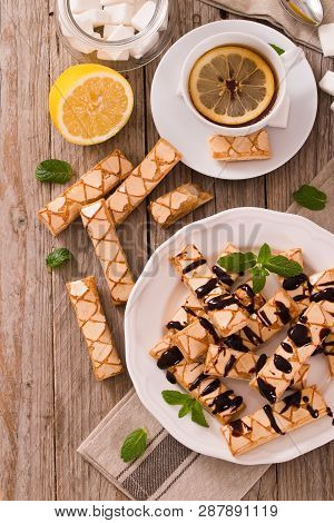 Puff Pastry Cookies With Chocolate Icing On White Dish.