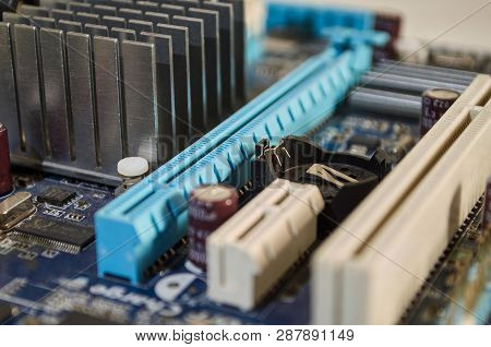 Macro Photograph Of Blue Pc Motherboard. Detailing Its Conectors, Coolers And Components.