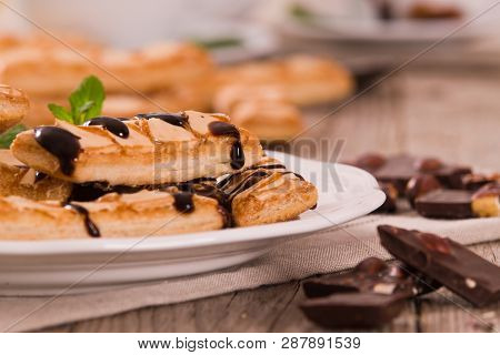 Puff Pastry Cookies With Chocolate Icing On White Dish.