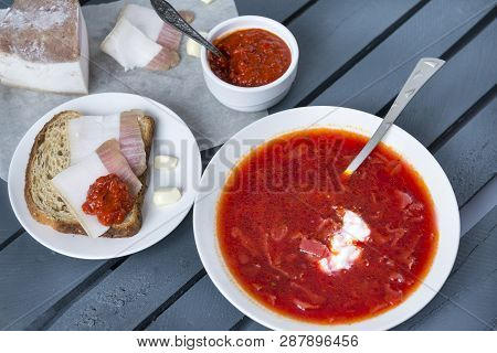 Plate With Borscht With Sour Cream, Borscht With Bacon, Bread, With Bacon Garlic And Ketchup On A Da