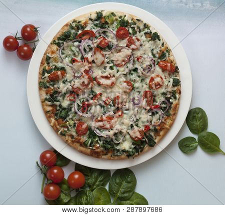 Spinach Pizza With Tomatoes And Parmesan With Fresh Spinach Leaves