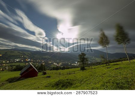 Summer Night Mountain Panorama. Small House Cottage On Steep Mountain Slope On Dramatic Evening Sky 