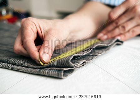 Tailor Using A Measure Tape To Measure Width Of Pants