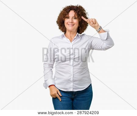 Beautiful middle ager senior businees woman over isolated background Smiling pointing to head with one finger, great idea or thought, good memory