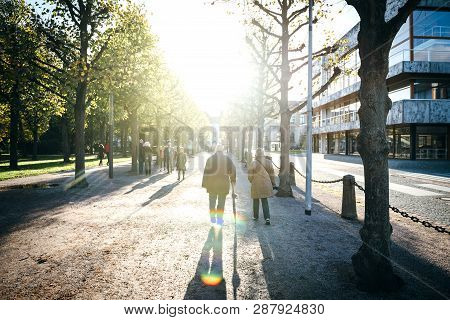 Karlsruhe, Germany - Oct 29 2017: Cinematic Scene With Peaceful Sunset And People Walking On Alley S